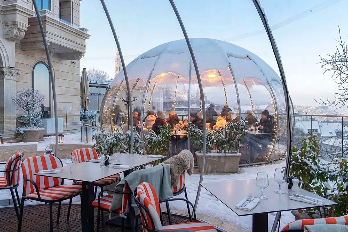 Fűtött igloo vendégekkel egy havas tetőteraszon