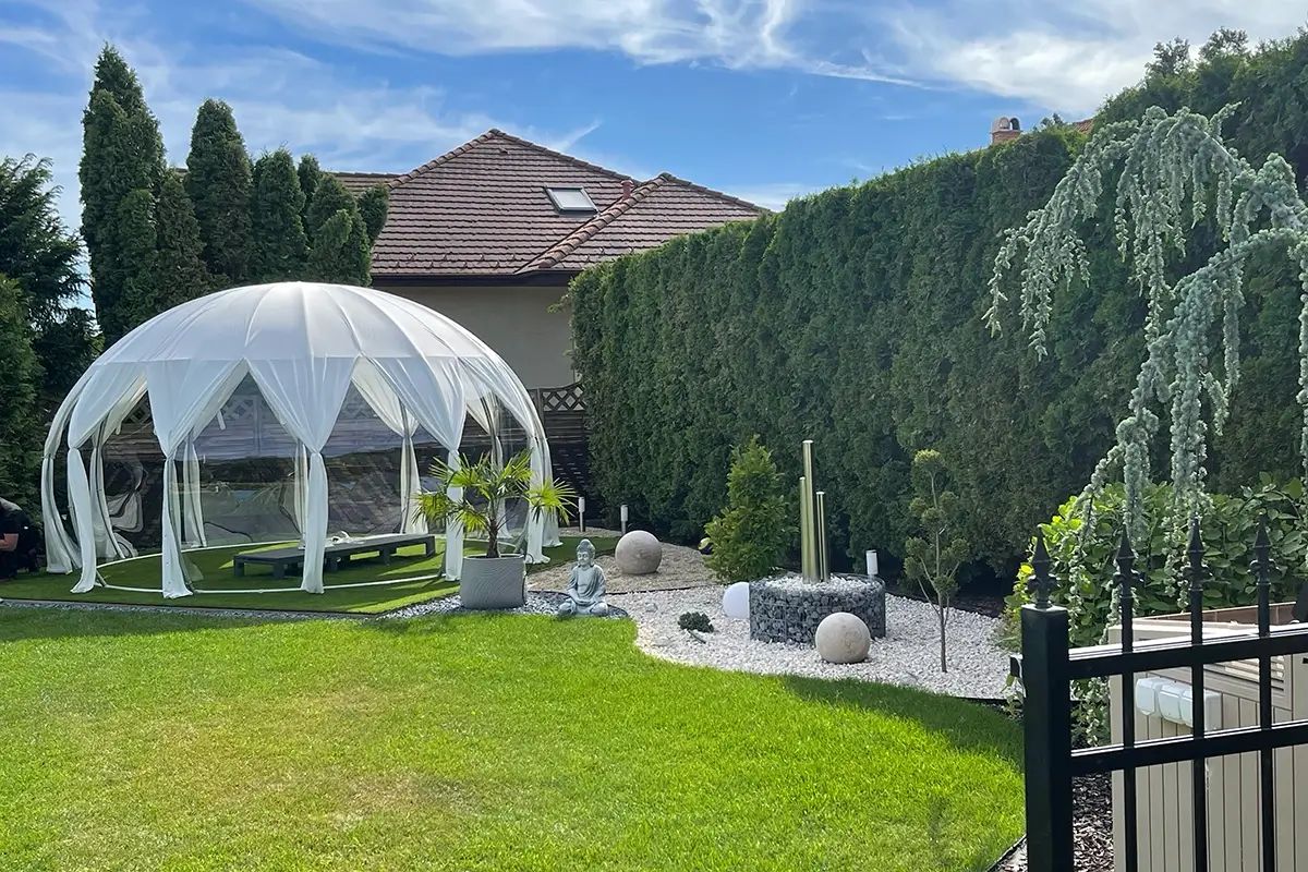 Árnyékoló borítású fehér igloo egy modern családi ház kertjében